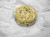 Pupusas para viagem costumam ser embaladas em plástico e depois em papel. (Aqui o papel foi desembalado para mostrar as pupusas)