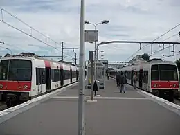 Dois trens MI 79 esperando perto das aldravas da estação.