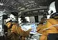 Astronautas da missão STS-107 na cabine do ônibus espacial.