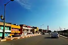 Fotografia de Souani com asfalto, estabelecimentos e carros