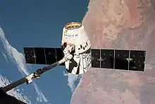 A Dragon sendo afastada da ISS pelo Canadarm2.
