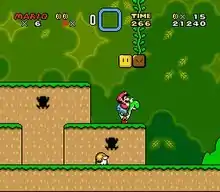 Esta captura de tela mostra Mario monta em Yoshi durante a primeira fase do jogo. O cenário mostra um ambiente de selva com blocos flutuantes espalhados pelo ar. A interface exibida nos cantos mostra o número de vidas que o jogador tem, as Dragon Coins coletadas, o power-up armazenado do jogador, o tempo restante da fase, o número de moedas e pontuação total do jogador.
