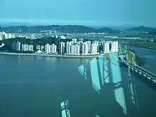 A ilha da Taipa (centro baixo, a ilha com mais prédios), a ilha de Coloane (centro cima) e uma parte da ilha de Hengqin (direita). Vista no terraço panorâmico da Torre de Macau.