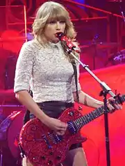 Taylor Swift cantando "Red" com uma guitarra elétrica