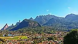 Vista parcial do bairro Carlos Guinle, com destaque para a Granja Comary e o lago a esquerda e as montanhas da Serra dos Órgãos ao fundo.