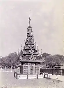 A imagem de 1906 exibe um túmulo real em Mandalay, Birmânia, da coleção do Serviço Arqueológico da Índia. Sob Taw Sein Ko, destaca-se pela torre pyatthat, revelando a riqueza artística birmanesa