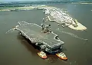 USS John F. Kennedy (CV-67) na Florida sendo guiado por rebocadores em 2002.