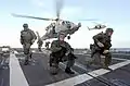 Um grupo de Navy SEALs desembarcando no navio.