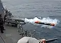 Um torpedo sendo disparado do convés do navio.