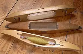 No topo, uma lançadeira "voadora" aberta sobre rolos. E duas outras fechadas, a de baixo é uma lançadeira assimétrica de estilo sueco com uma bobina de papelão. Todas elas são alimentadas lateralmente.