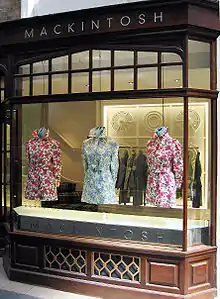 A row of Mackintoshes laid out in a storefront.